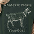 Person wearing a dark green t-shirt with a goat graphic and text, sitting in a cozy indoor setting.